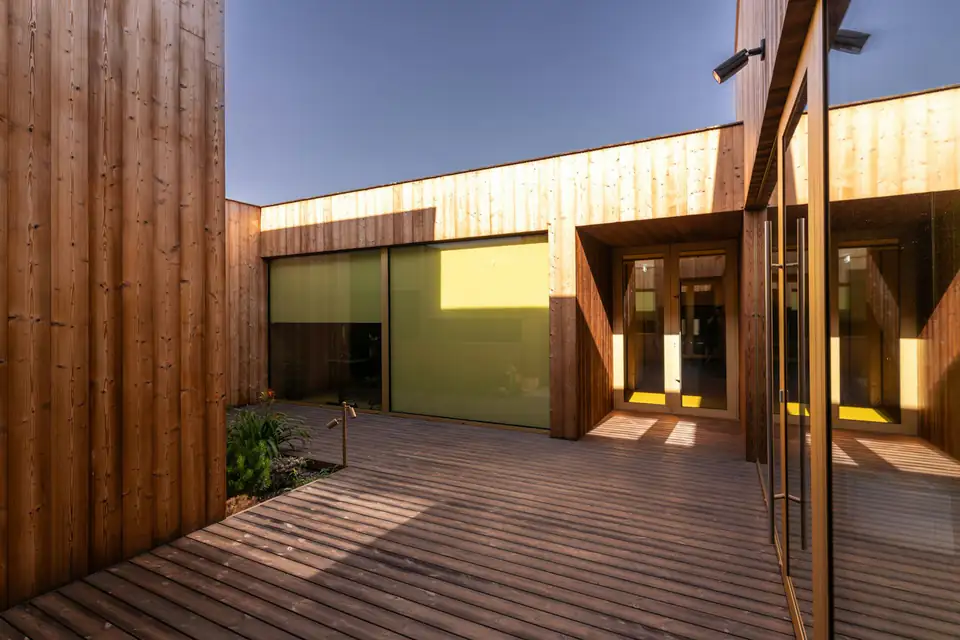 Timber-clad garden room with full-height glazing, design inspiration for bespoke garden rooms in Newcastle Timber-clad bespoke garden room with large glazed panels and a deck, a design idea for Newcastle gardens