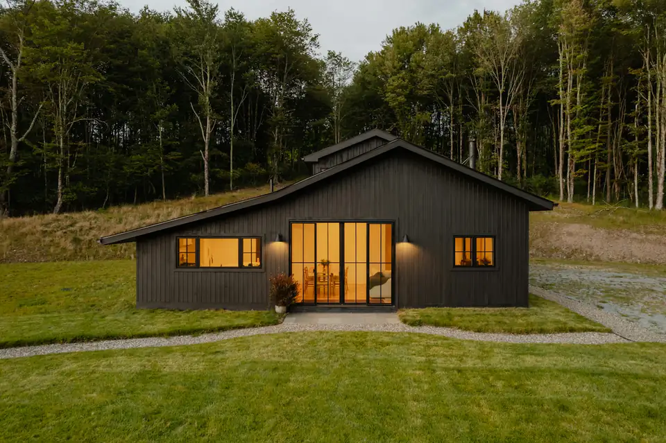 Insulated garden room with warmly lit windows, design inspiration for garden rooms in Newcastle Dark-clad garden building with warmly lit windows at dusk, inspiration for a garden room in the North East