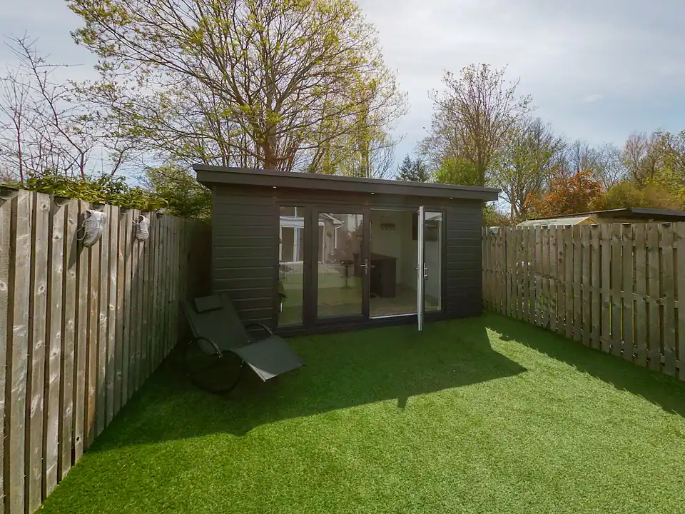 Dark-clad garden office at the end of a fenced lawn, a design idea for Gateshead gardens